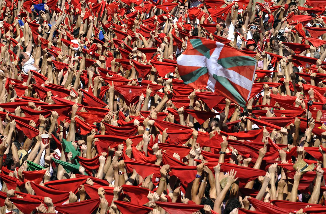 Miles de personas lanzan el tradicional "pañuelico" rojo en la Plaza del Ayuntamiento durante el lanzamiento del chupinazo, con el que a las doce del mediodía han dado comienzo las fiestas de San Fermín.