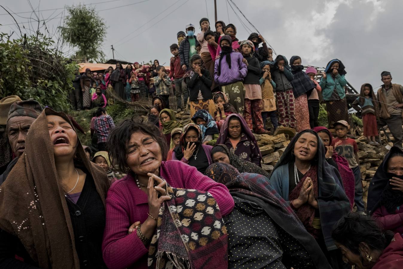 Fotografía de la serie ganadora del Premio categoría 'Historias'. tercer premio en "Historias" de la categoría individual de noticias de actualidad de la 59 edición del World Press Photo, tomada por el fotógrafo australiano del New York Times Daniel Berehulak. La fotografía muestra varias mujeres llorando mientras el cuerpo sin vida de la pequeña Rejina Gurung de tres años es recuperado de entre los escombros, en Gumda (Nepal) el 8 de mayo de 2015