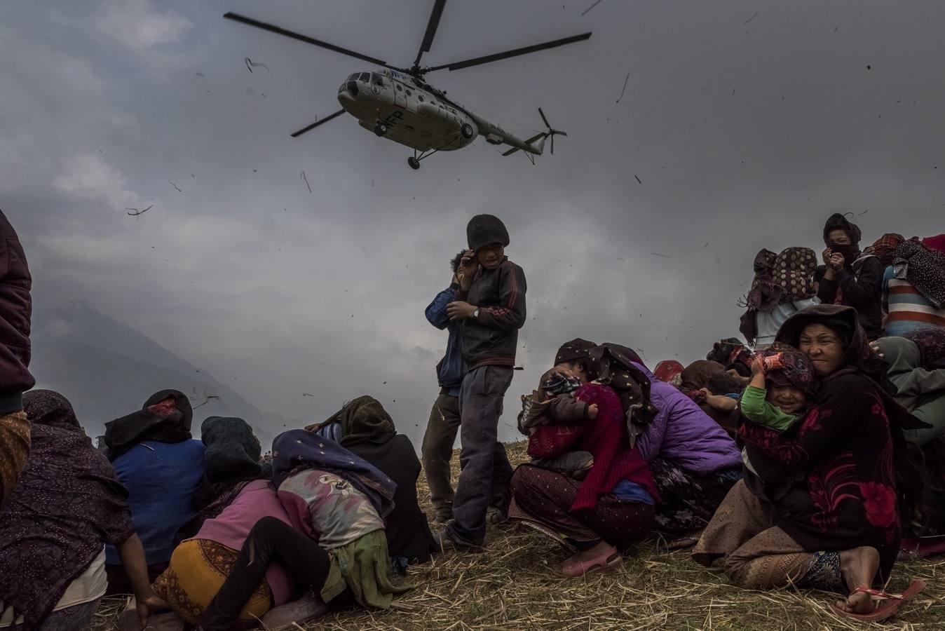 Ganadora en "Historias" del tercer premio de la categoría individual de noticias de actualidad. La fotografía muestra a varias personas que aguardan la llegada del helicóptero con la ayuda sanitaria en Gumda (Nepal) el 9 de mayo de 2015, tras el terrible terremoto que se cobró más de 8.000 vidas.