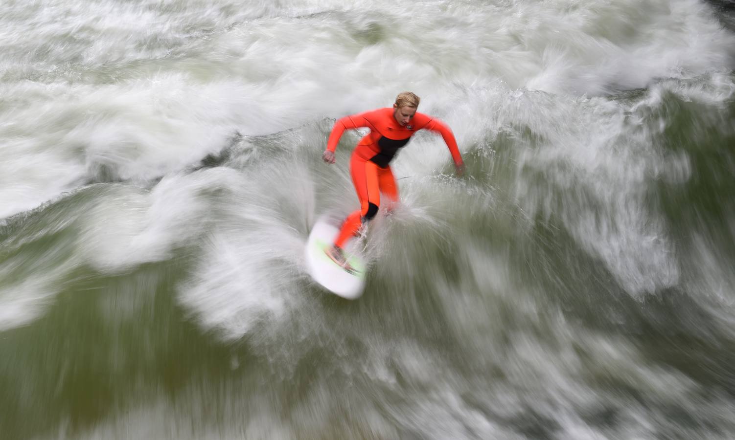 Jóvenes practican surf en el canal de Eisbach, al sur de Alemania