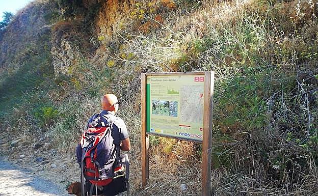 Senderista informándose en un panel informativo