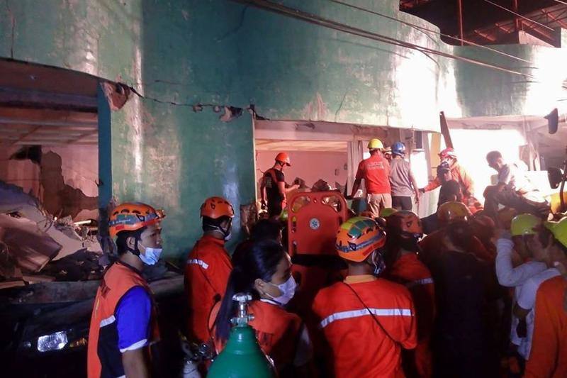 Los bomberos elaboran las labores de rescate de las personas atrapadas en los edificios destruidos por el terremoto