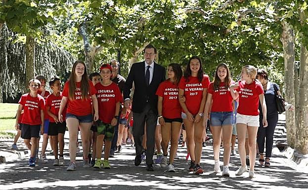 Mariano Rajoy pasea por los jardines de Moncloa junto a los hijos de los empleados del complejo.