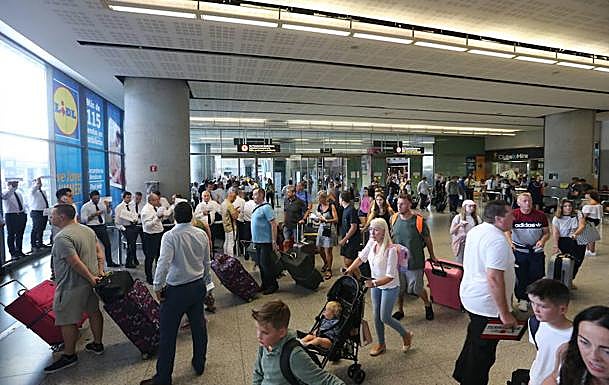 Pasajeros cargados de maletas en la zona de Llegadas del Aeropuerto de Málaga. 