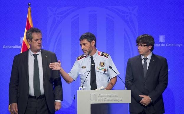 El mayor de los Mossos d'Esquadra, Josep Lluís Trapero, entre el presidente catalán, Carles Puigdemont (d) y el conseller de Interior, Joaquim Forn (i). 