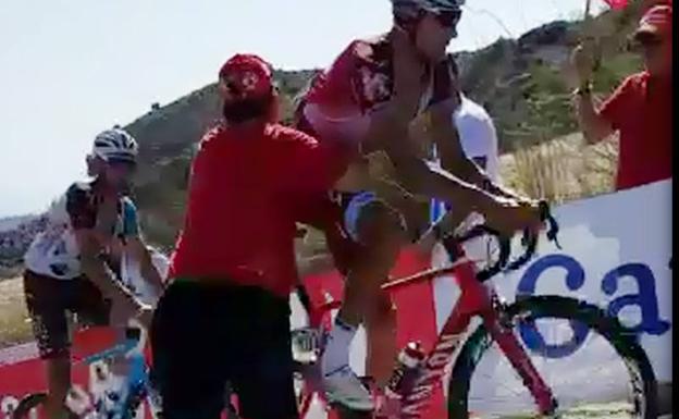 Momento en el que un aficionado empuja al ciclista.