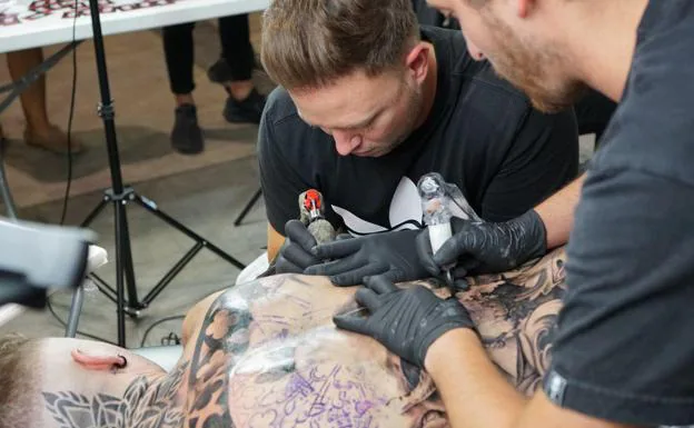 Un joven se tatúa la espalda completa en el evento Full Back Tattoo.