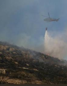 Imagen secundaria 2 - En la imagen superior, un operario retira los coches de un parking cercano. A la izquierda, las llamas afectaron a los pilares de la M-23. Al lado, agentes de Infoca sofocan otro incendio en una zona forestal de Puerto de la Torre.