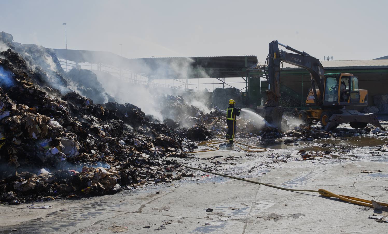 Los bomberos continúan con las labores de refresco de la nave incendiada este sábado