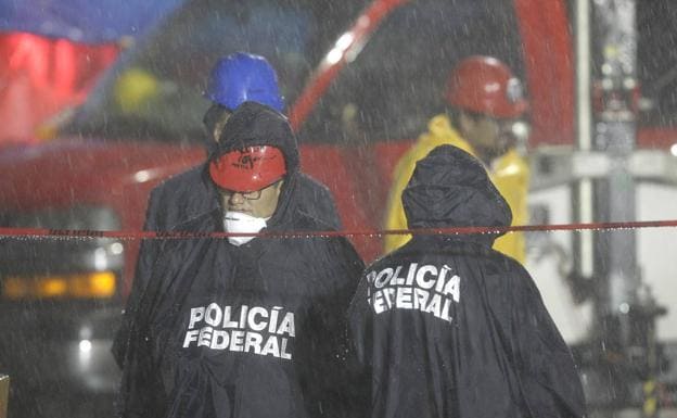 Policías federales bajo la fuerte lluvia que detuvo los trabajos de rescate este martes 26 en el edificio de Álvaro Obregón.