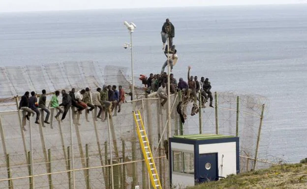 Inmigrantes intentan cruzar la valla de Melilla.