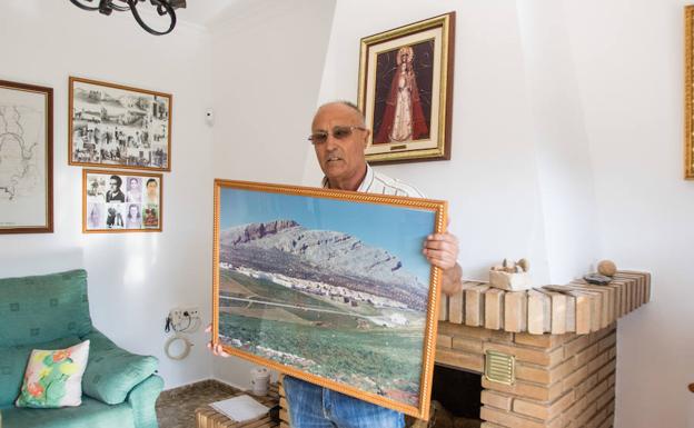 Juan Mora en su casa de Peñarrubia junto a una fotografía. 