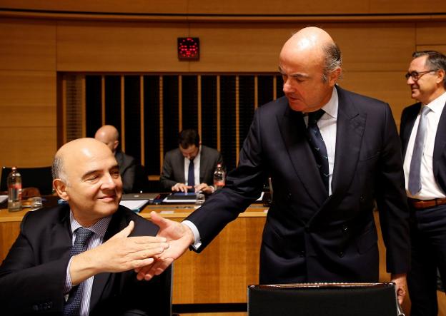 El ministro de Economía, Luis de Guindos, saluda al comisario de Asuntos Económicos de la UE. :: efe