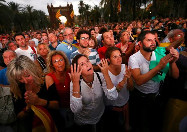 En la imagen superior, un grupo de personas celebra la declaración de independencia. Abajo, reaccionan tras escuchar su suspensión. :: Iván Alvarado / reuters