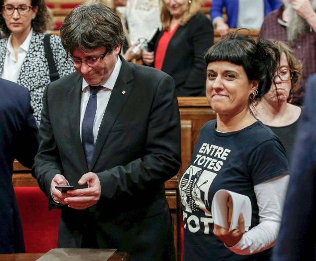 La diputada de la CUP Anna Gabriel pasa por delante de Carles Puigdemont en la sesión del pasado martes del Parlament. :: A. Gea / reuters