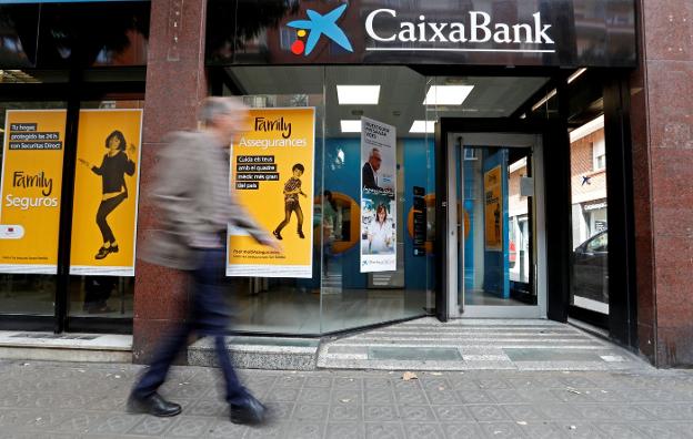 Fachada de una de las sucursales de CaixaBank en Barcelona. :: y. herman / reuters