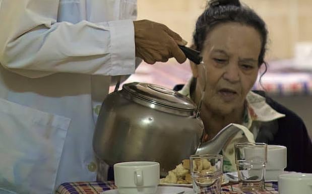 Una voluntaria sirve en el comedor del Cottolengo. 