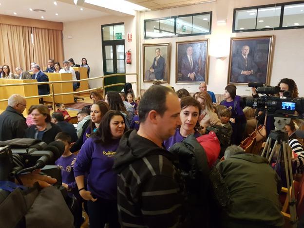 Madres y padres de alumnos del colegio Reñidero abandonando el pleno ayer con sus hijos.