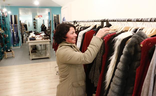 Una mujer mira ropa en una tienda.