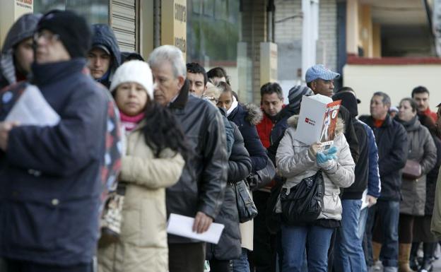 Cola de personas ante las puertas de una oficina de empleo.