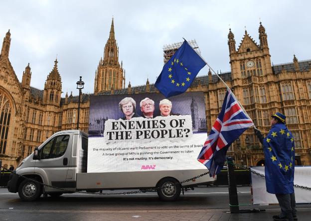 Un hombre, con una bandera europea o otra británica, ayer en una protesta contra el 'brexit' ante el Parlamento de Londres. :: F. A. / efe
