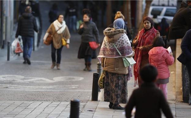 Dos mujeres conversan en una calle del multicultural barrio de Lavapiés, en Madrid.