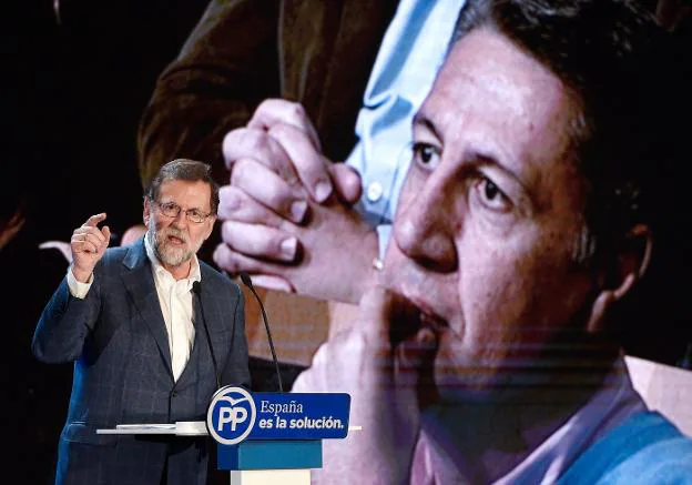Rajoy interviene en el acto del PP en Salou con una imagen de Albiol como fondo de escenario. ::  LLUíS GENé / afp