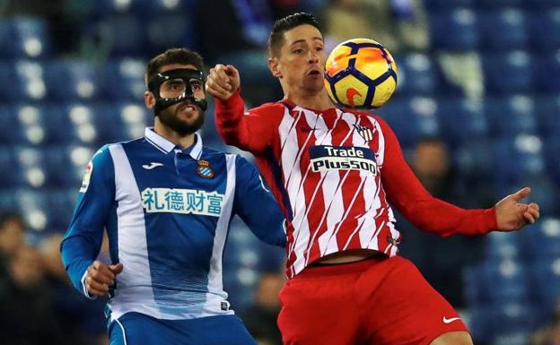 Fernando Torres protege el balón ante David López. 