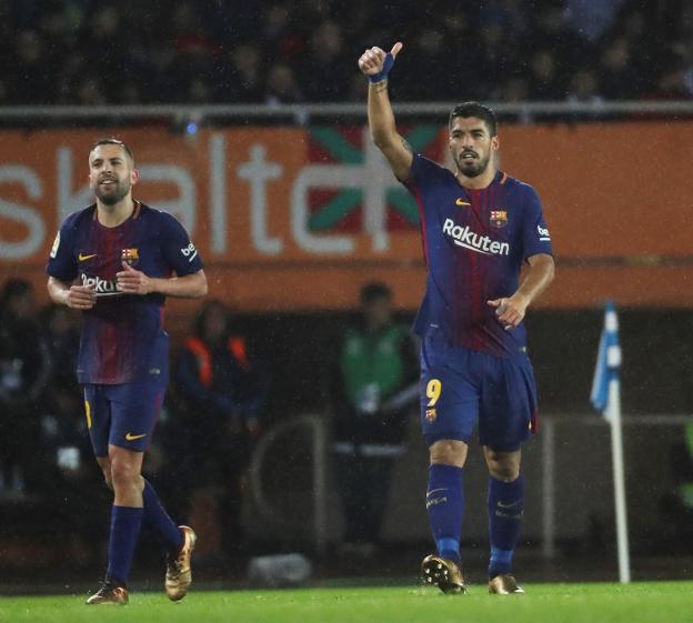 Luis Suárez levanta el pulgar para festejar ayer el tercer gol del Barça en Anoeta, mientras Jordi Alba sonríe. :: Javier Etxezarreta / EFE