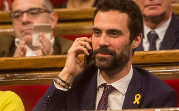 El diputado de ERC, Roger Torrent, conversa por teléfono con el expresidente de la Generalitat, Carles Puigdemont , tras su elección como nuevo presidente del Parlament.