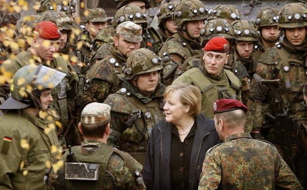 Merkel habla con un grupo de soldados alemanes.