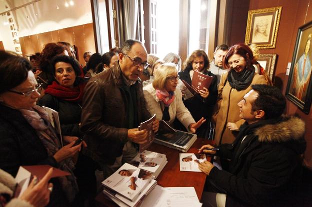 El pintor, firmando los catálogos de su obra. :: a. j. g.