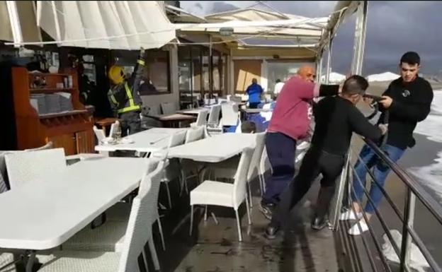 El viento se lleva la cubierta de la terraza de un chiringuito de Huelin