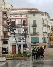 Imagen secundaria 2 - En la foto de arriba, daños en el chiringuito El Torillo, en Fuengirola. Abajo, el paseo marítimo de Poniente; y los bomberos intervienen por una farola a punto de caerse junto al Marqués de Larios en Málaga. 
