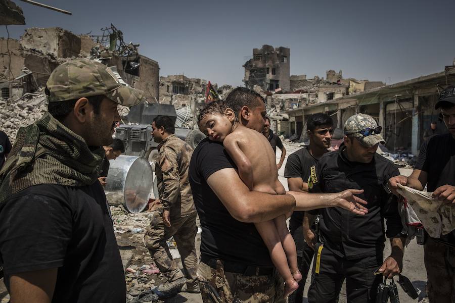 Autor: Ivor Prickett (Irlanda). Liberación de Mosul del Estado Islámico por parte de las fuerzas iraquíes. En la foto, un niño no identificado, que fue llevado fuera de la última área controlada por ISIS en la Ciudad Vieja por un hombre sospechoso de ser un militante, recibe los cuidados de soldados de las Fuerzas Especiales iraquíes.