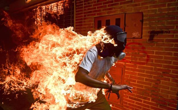 Fotografía tomada por Ronaldo Schemidt en la que se ve a un manifestante envuelto en llamas en una de las revueltas en Caracas.