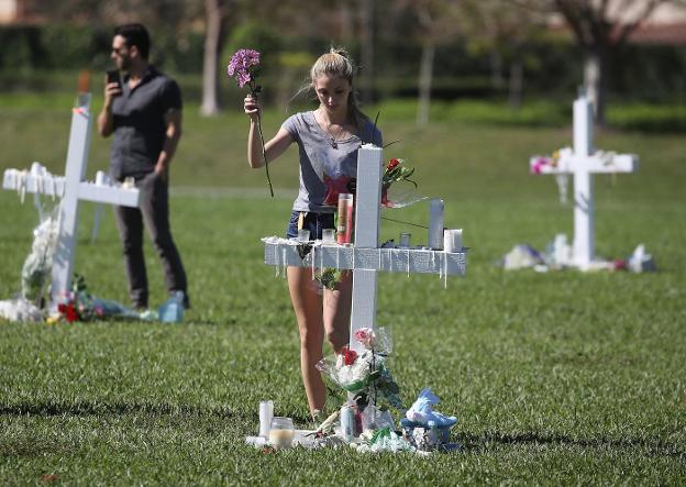 Una joven deposita flores en el memorial de las víctimas. 