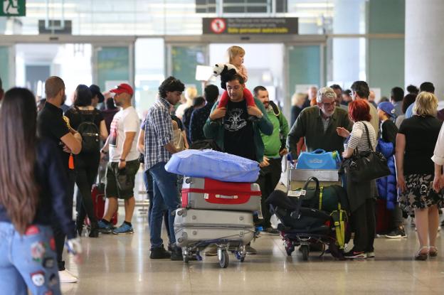 Pasajeros transitan por la terminal del aeropuerto de Málaga en busca de sus mostradores para facturar las maletas. :: fernando González