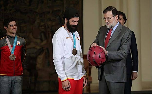 Regino Hernández regaló a Mariano Rajoy un casco. Detrás de ellos, Javier Fernández.
