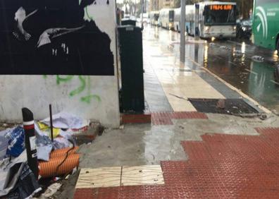 Imagen secundaria 1 - Acceso a los Baños del Carmen. La señal, rodeada de basuras. Boquetes en la calzada, la plaza de la Marina.