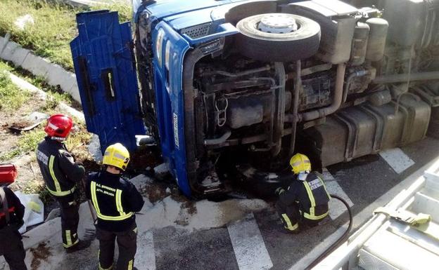 Bomberos actúan tras el vuelco lateral de un camión cerca del centro de transportes en Málaga