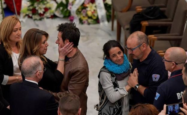 Susana Díaz y miembros de los bomberos dan el pésame a los padres de Gabriel durante la capilla ardiente. 