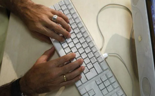 Imagen de archivo de un hombre trabajando con un ordenador.