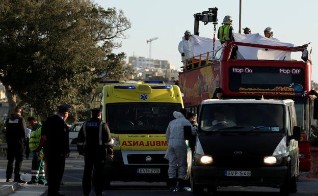 Miembros de los equipos de rescate transportan uno de los cadáveres. 