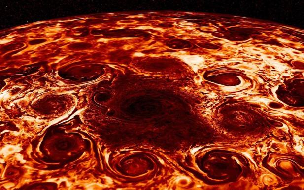 Fotografía facilitada por la NASA, de los ciclones gigantes que sus científicos responsables de la misión Juno han encontrado en el polo norte de Júpiter. 