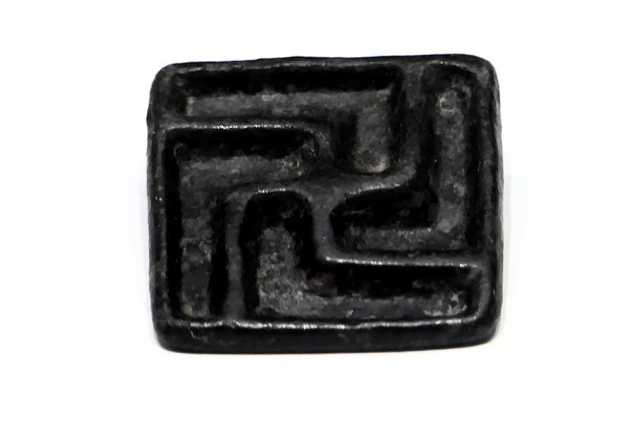 Botón metálico con la esvástica del siglo I a.C. aparecido en la necrópolis de Huerta Primera en Cártama