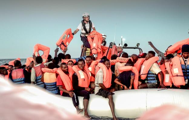 Miembros del 'Aquaruis' reparten chalecos salvavidas entre los tripulantes de una de las embarcaciones rescatada. :: reuters