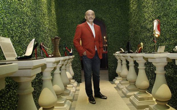 Christian Louboutin, junto a algunos de sus zapatos. 