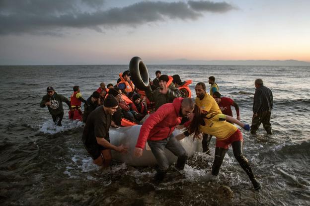 Voluntarios ayudan a desembarcar en la isla griega de Lesbos a un grupo de inmigrantes. :: pedro armestre / save the children