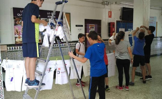 Alumnos colgando las camisetas en uno de los pasillos del IES Salvador Rueda.